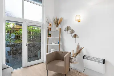 a living room with a chair and a window at Coppercroft Cottage - Stunning Coastal Home, Walk to Beach, Sleeps 4 in Porthtowan