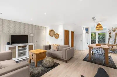 a living room with a couch and a table at Coppercroft Cottage - Stunning Coastal Home, Walk to Beach, Sleeps 4 in Porthtowan