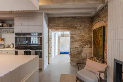 a kitchen with a brick wall and a chair at Finest Retreats - ARC Padstow in Little Petherick