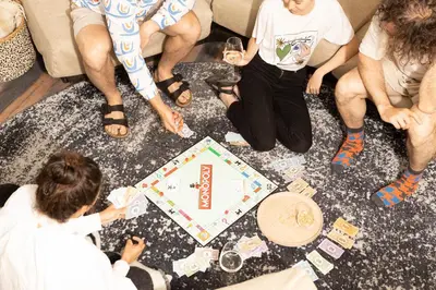 a group of people sitting on the floor playing a board game at Finest Retreats - ARC Padstow in Little Petherick