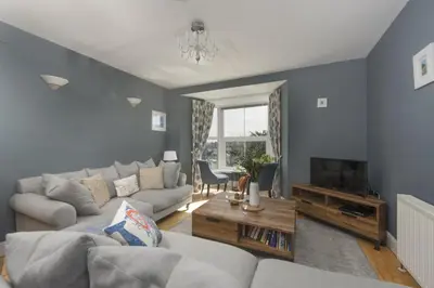 a living room with a couch and a tv at Windsor Lookout in St Ives