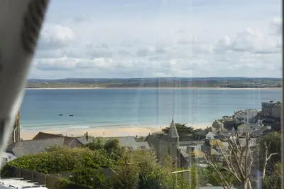 a view of a city and a beach from a window at Windsor Lookout in St Ives