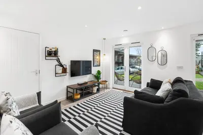 a living room with two couches and a tv at Silvercroft Cottage - Luxury Modern Coastal Retreat Near Beach, Sleeps 4 in Porthtowan