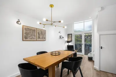 a dining room with a wooden table and black chairs at Silvercroft Cottage - Luxury Modern Coastal Retreat Near Beach, Sleeps 4 in Porthtowan
