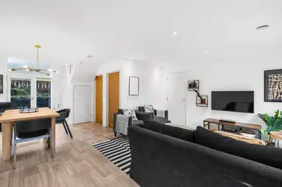 a living room with a couch and a table at Silvercroft Cottage - Luxury Modern Coastal Retreat Near Beach, Sleeps 4 in Porthtowan