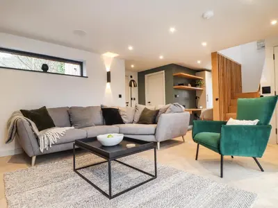 a living room with a couch and two chairs at The Granary at Boskensoe Barns in Falmouth