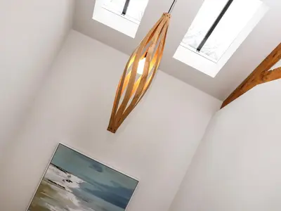 a staircase with skylights and a painting on the wall at The Granary at Boskensoe Barns in Falmouth