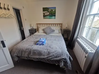 a bedroom with a bed with a blue towel on it at Malahne Apartment Port Isaac in Port Isaac