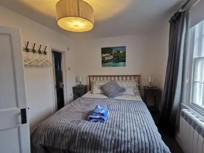 a bedroom with a bed with a blue towel on it at Malahne Apartment Port Isaac in Port Isaac
