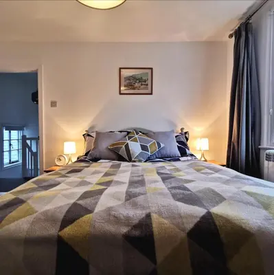 a bedroom with a large bed with two lamps at Malahne Apartment Port Isaac in Port Isaac