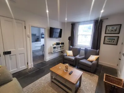 a living room with a couch and a table at Malahne Apartment Port Isaac in Port Isaac