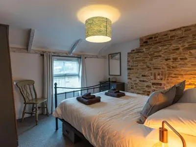 a bedroom with a bed and a brick wall at Finest Retreats - Old Harbour Cottage in Mevagissey