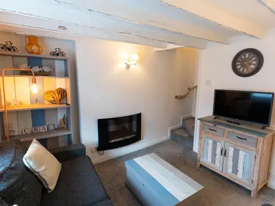 a living room with a fireplace and a tv at Finest Retreats - Old Harbour Cottage in Mevagissey