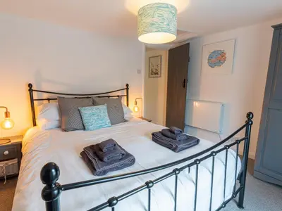 a bedroom with a large bed with towels on it at Finest Retreats - Old Harbour Cottage in Mevagissey