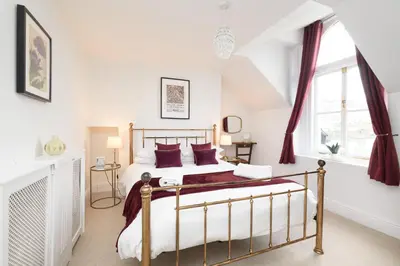 a bedroom with a bed and two windows at Superb House in Looe, Near Beach and Bars with Great Views and free access to a nearby Indoor Swimming Pool in Looe