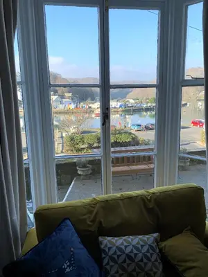a couch sitting in front of a large window at Superb House in Looe, Near Beach and Bars with Great Views and free access to a nearby Indoor Swimming Pool in Looe