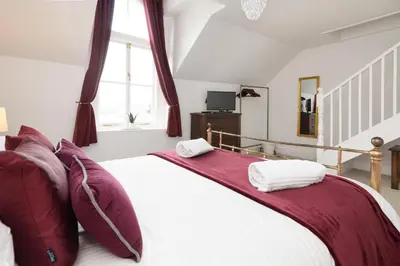 a bedroom with a large bed with purple pillows at Superb House in Looe, Near Beach and Bars with Great Views and free access to a nearby Indoor Swimming Pool in Looe