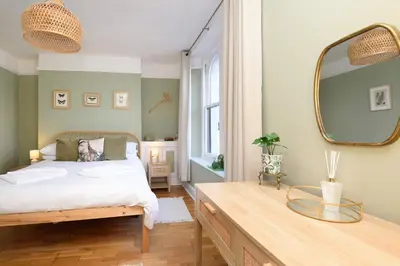 a bedroom with a bed with a mirror and a table at Superb House in Looe, Near Beach and Bars with Great Views and free access to a nearby Indoor Swimming Pool in Looe