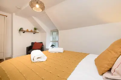 a bedroom with a large bed with towels on it at Superb House in Looe, Near Beach and Bars with Great Views and free access to a nearby Indoor Swimming Pool in Looe