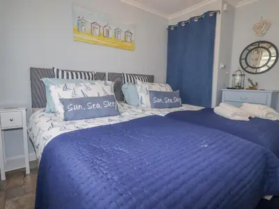 a blue bed with blue sheets and pillows on it at Merryfield Lodge in Liskeard