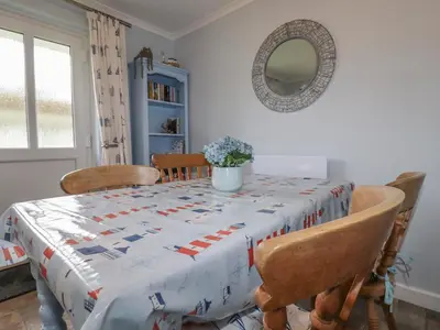 a dining room table with a quilt on it at Merryfield Lodge in Liskeard