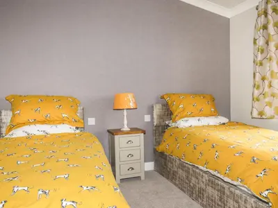 two beds sitting next to each other in a bedroom at Acorn Lodge in Redruth