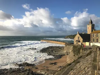 a church on a cliff next to the ocean at Cliff House - a stunning sea view 2 bed apartment in Porthleven in Porthleven