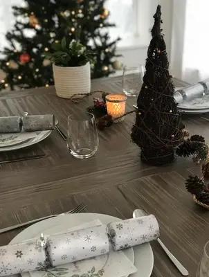 a christmas table with a christmas tree in the background at Cliff House - a stunning sea view 2 bed apartment in Porthleven in Porthleven