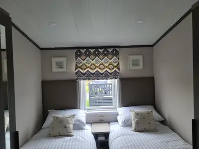 two beds in a small room with a window at Mawgan Pads Perranporth in Cubert