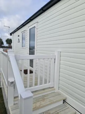 a white house with a porch and a white railing at Mawgan Pads Perranporth in Cubert