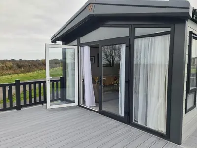 a house with sliding glass doors on a deck at Mawgan Pads Perranporth in Cubert