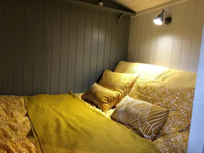 a bed with pillows on it in a room at Miners Hut in St Austell