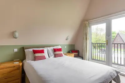 a bedroom with a large bed with red and white pillows at Lodges in Lanivet Cornwall with indoor pool in Bodmin