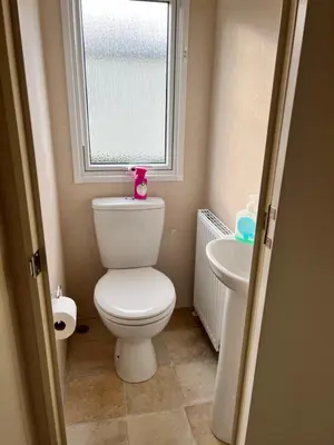 a small bathroom with a toilet and a window at Mollys Retreat pet friendly three bed caravan with small garden Newquay Bay Resort Quieter area of park in Newquay