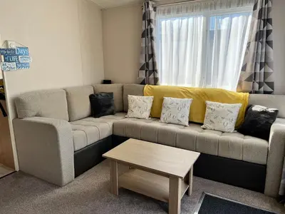 a living room with a couch and a coffee table at Mollys Retreat pet friendly three bed caravan with small garden Newquay Bay Resort Quieter area of park in Newquay