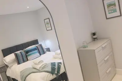 a mirror in a bedroom with a bed and a dresser at Townhouse, close to harbour with sea views in Padstow