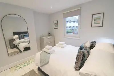 a bedroom with two beds and a mirror at Townhouse, close to harbour with sea views in Padstow