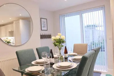 a dining room with a table and chairs and a mirror at Townhouse, close to harbour with sea views in Padstow