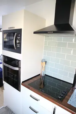 a kitchen with a stove top oven next to a microwave at 12a Mault-Ley Studio in St Ives