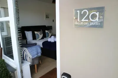 a room with a bed and a sign on the wall at 12a Mault-Ley Studio in St Ives