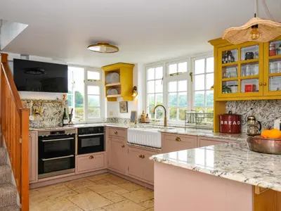 a kitchen with yellow cabinets and a counter top at Island House in Fowey