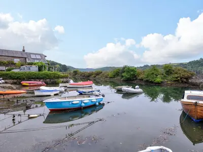 a group of boats are docked in a river at Island House in Fowey