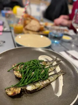 a plate of fish with green beans on a table at Daphne's Lodge in Mawgan Porth