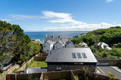 a house on a hill with the ocean in the background at Del Mar in St Ives