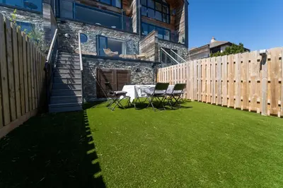 a patio with a table and chairs on a lawn at Del Mar in St Ives