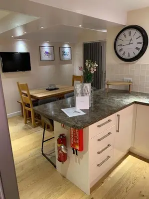 a kitchen with a counter and a clock on the wall at 44 Raleigh Close@Padstow in Padstow