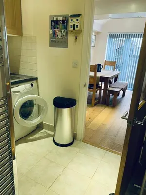 a kitchen with a washing machine and a dining room at 44 Raleigh Close@Padstow in Padstow
