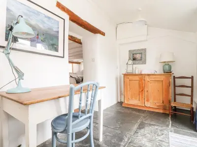 a dining room with a desk and a chair at Trelash Cottage in Launceston