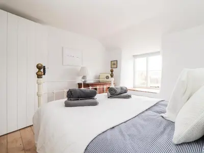 a white bedroom with a bed with two pillows on it at Trelash Cottage in Launceston
