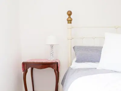 a bed with a side table next to a bed at Trelash Cottage in Launceston